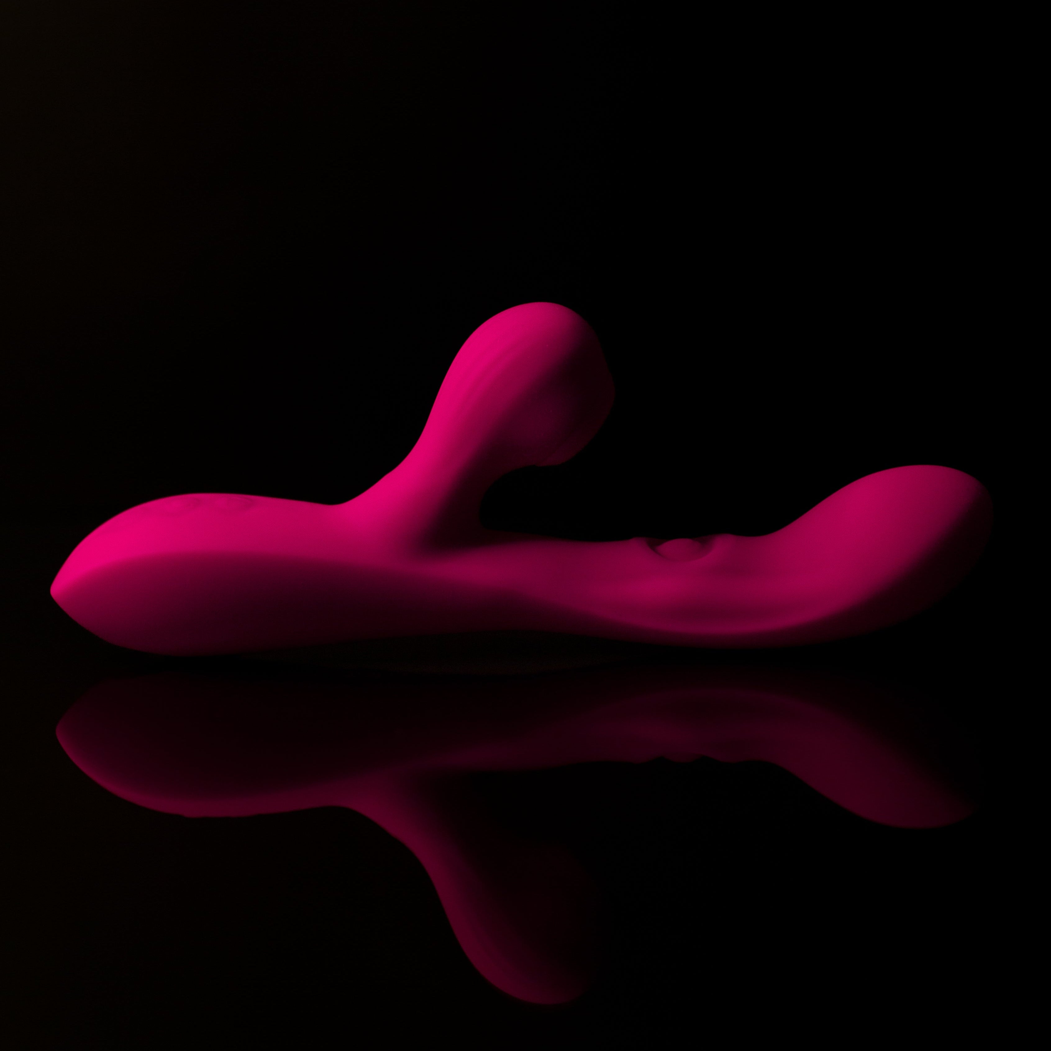 Pink pleasure toy with reflection on a black background