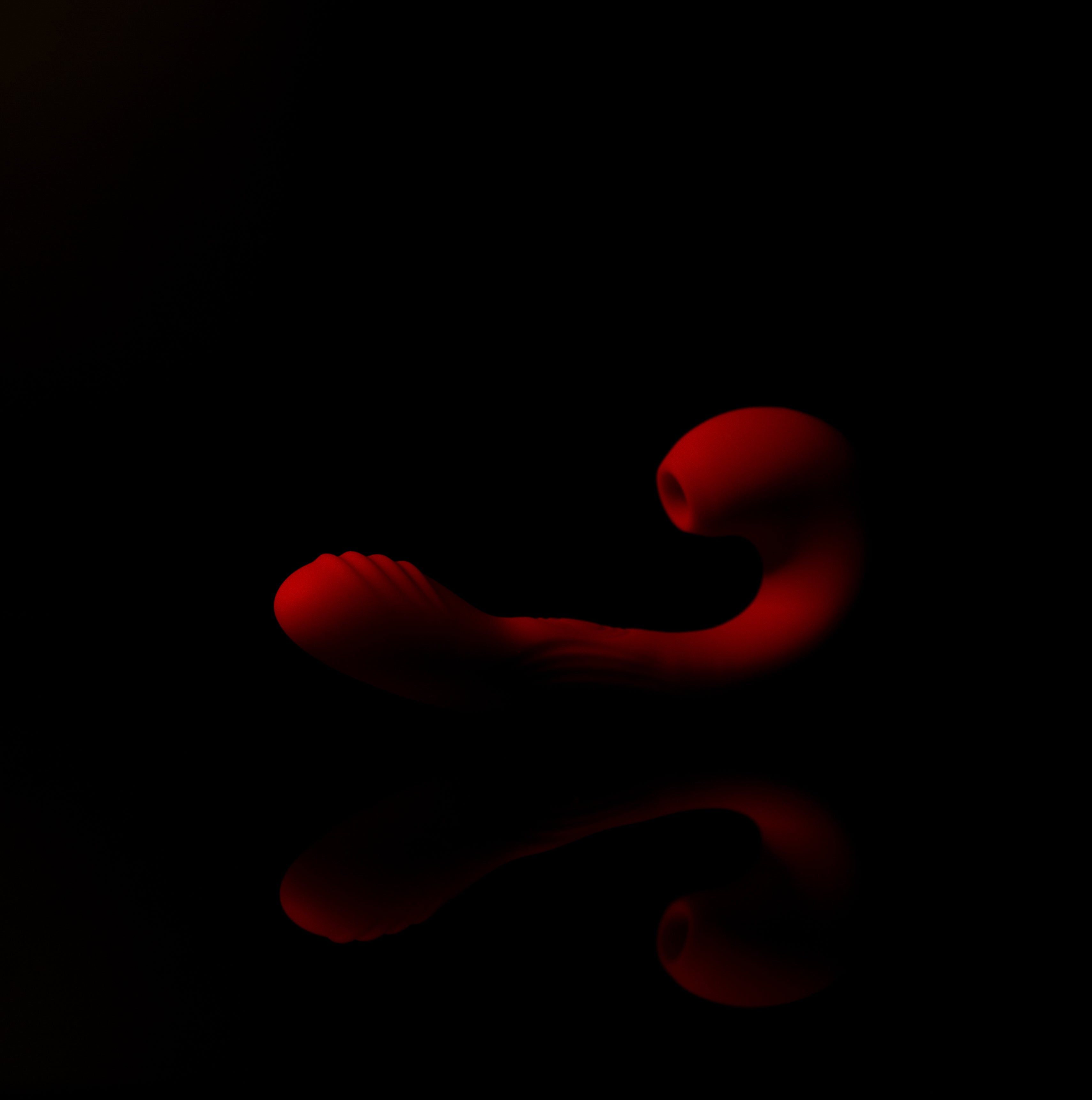 Red vibrating toy on a black background