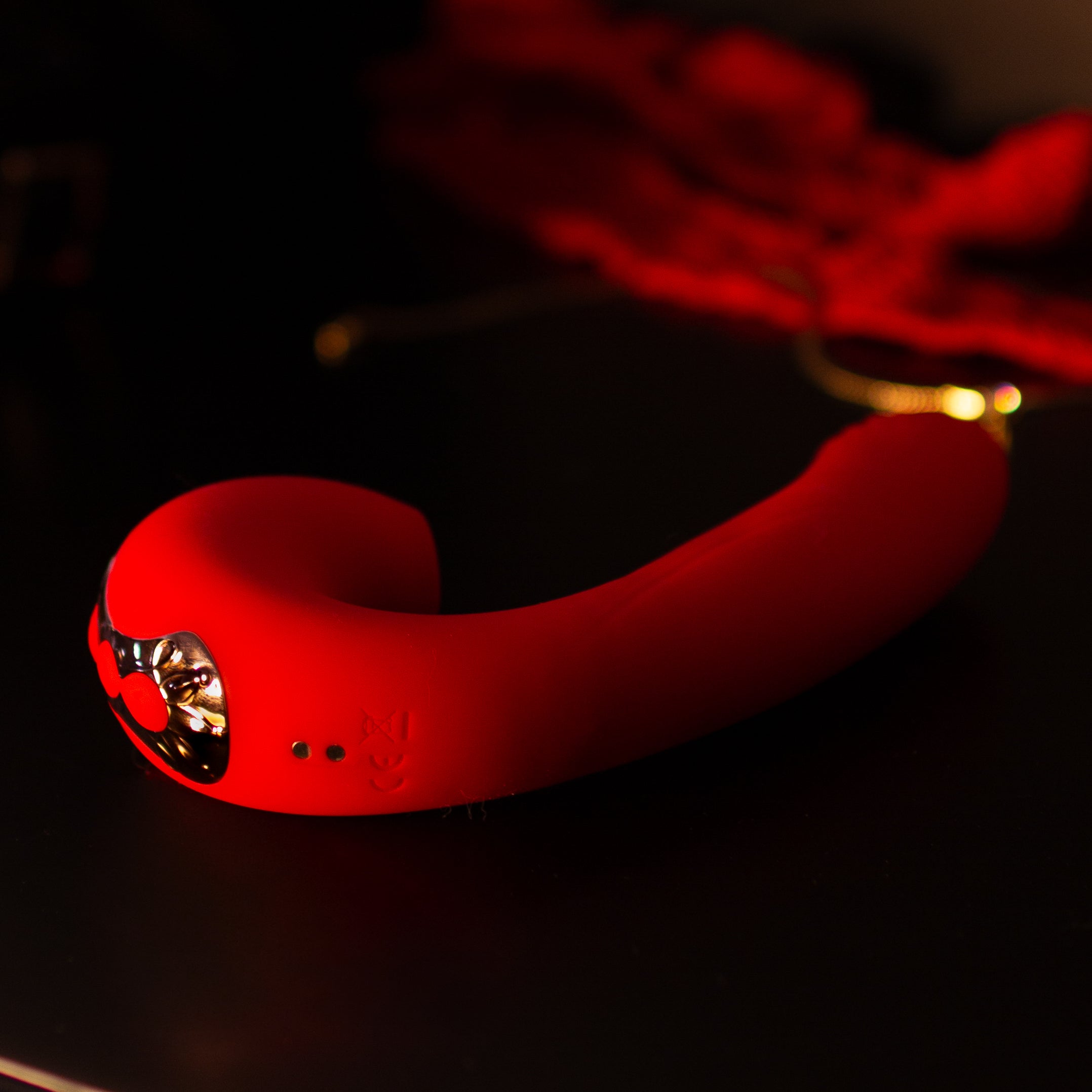 Red pleasure toy on a dresser in the dark